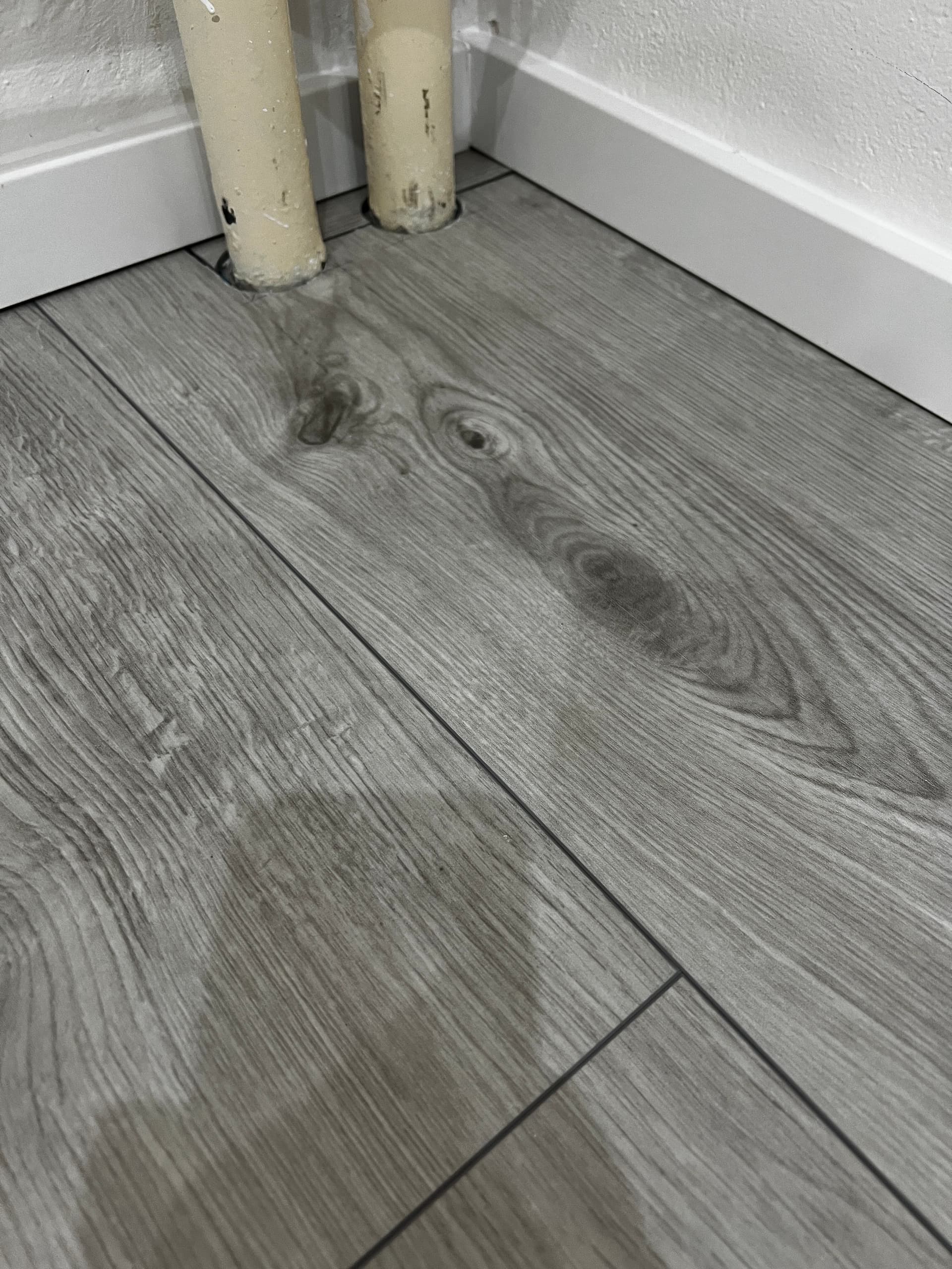 Detail laminátovej podlahy pri rúrkach